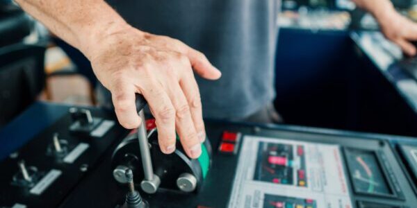 Captain of deck Officer on bridge of vessel or ship during navigaton watch at sea . He is maneuvering with cpp thrusters propulsion and bowthruster. Closeup view